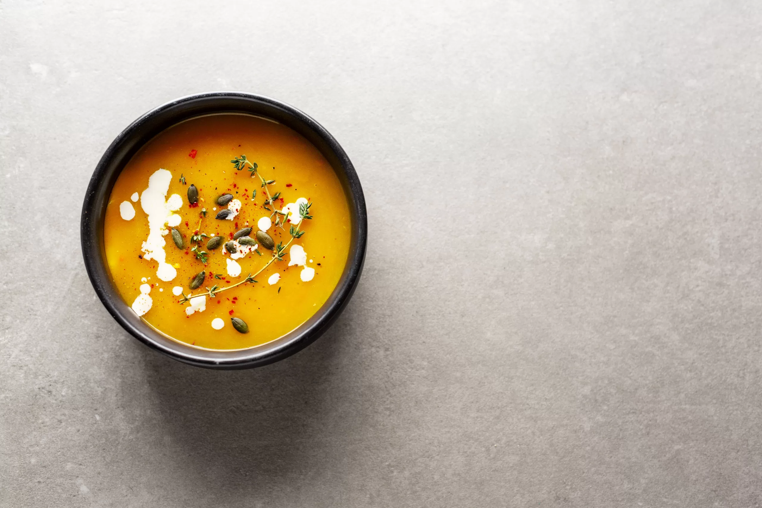 Creamy pumpkin soup served in bowl